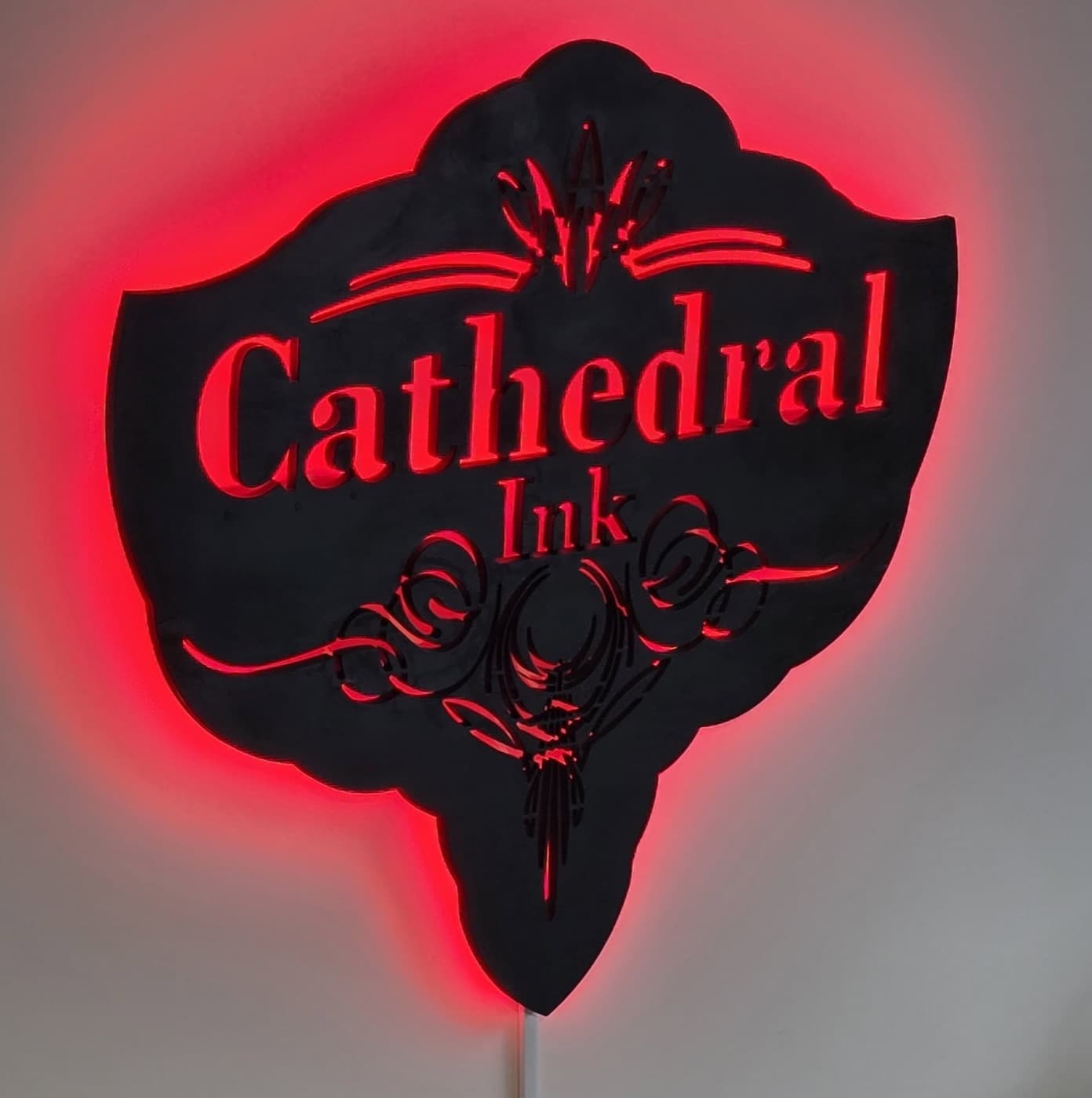 Cathedral Ink's red backlit sign above the shop door