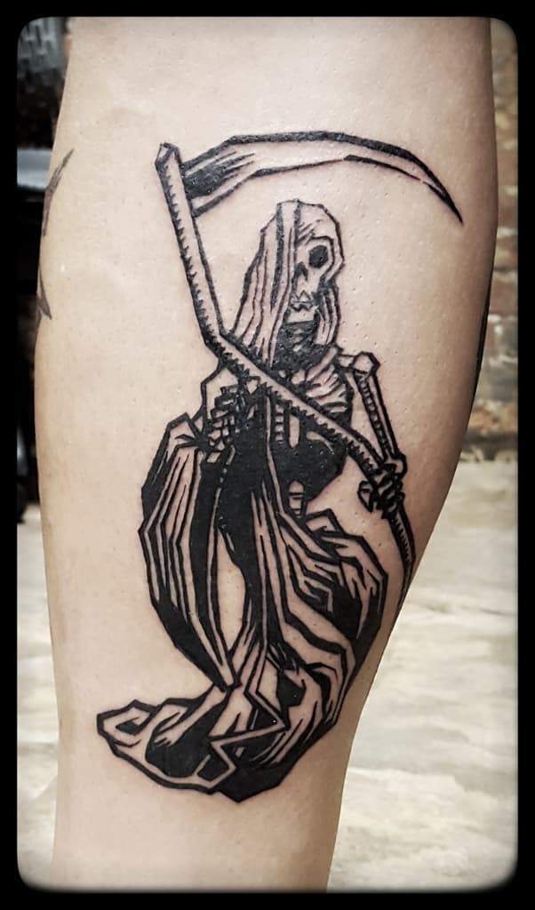 Hooded grim reaper holding a scythe, bold black woodcut-style linework on the calf