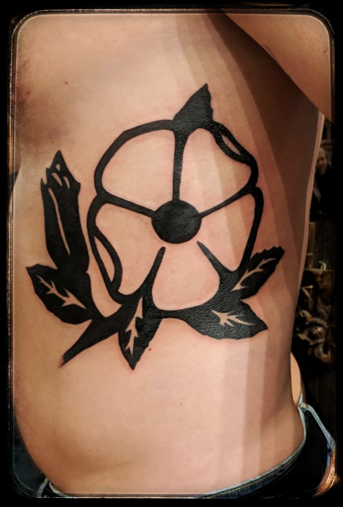 Five-petal flower outline with solid leaves, bold blackwork on the side of the ribs