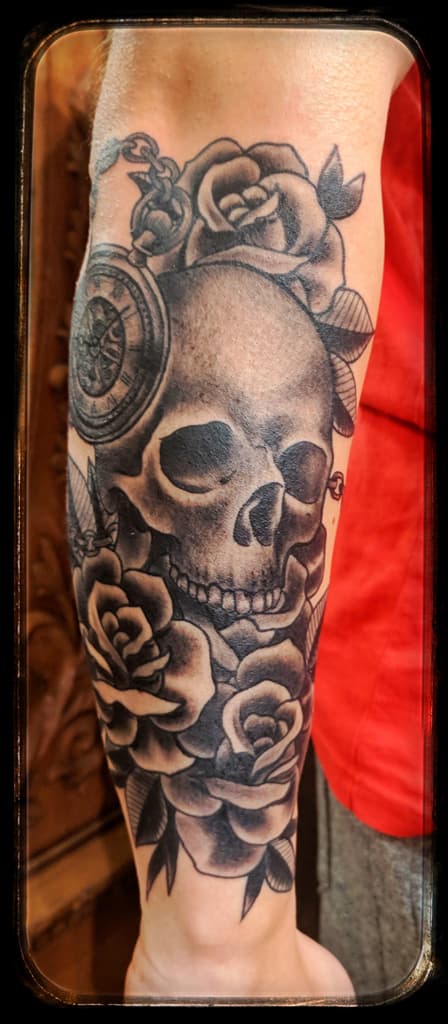 Human skull among roses with a pocket watch on a chain, black and grey forearm sleeve